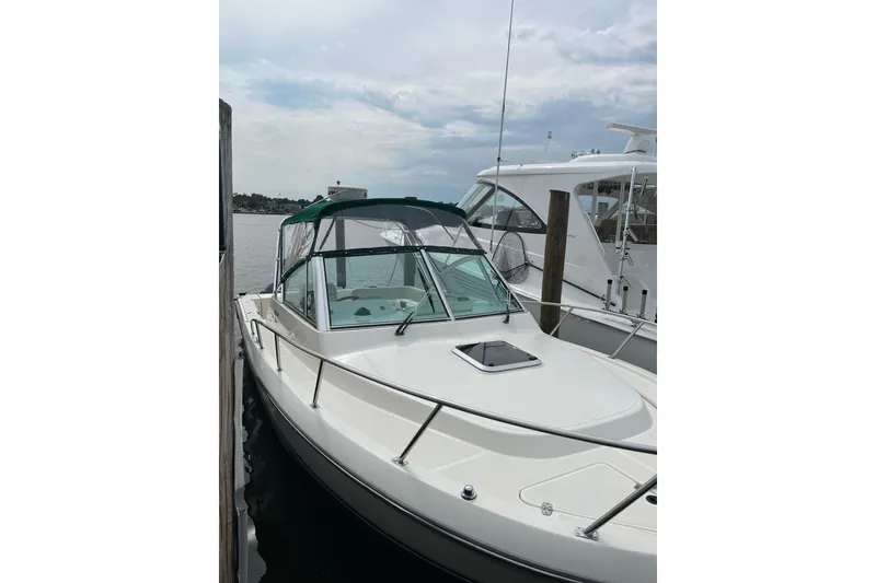Slide: The Image of 2000 Pursuit 2860 Denali boat docked at marina under cloudy sky. - 5