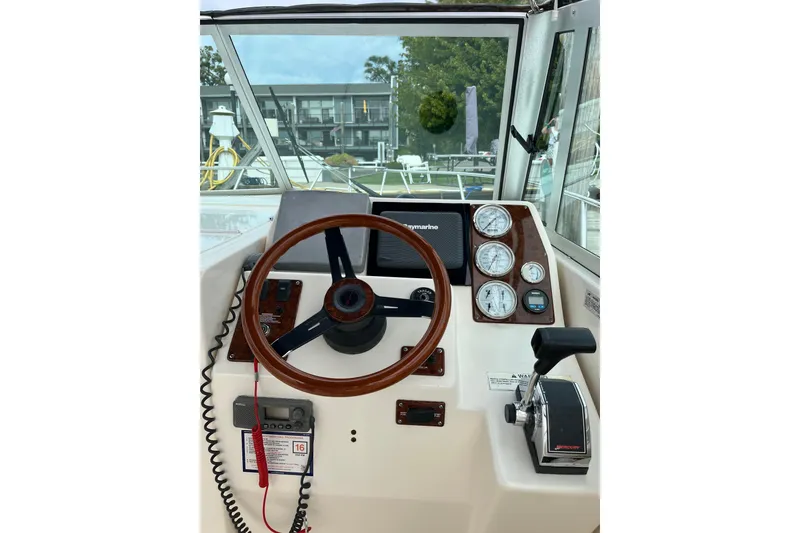 Slide: The Image of Helm of 2000 Pursuit 2860 Denali boat with steering wheel and control panel. - 12