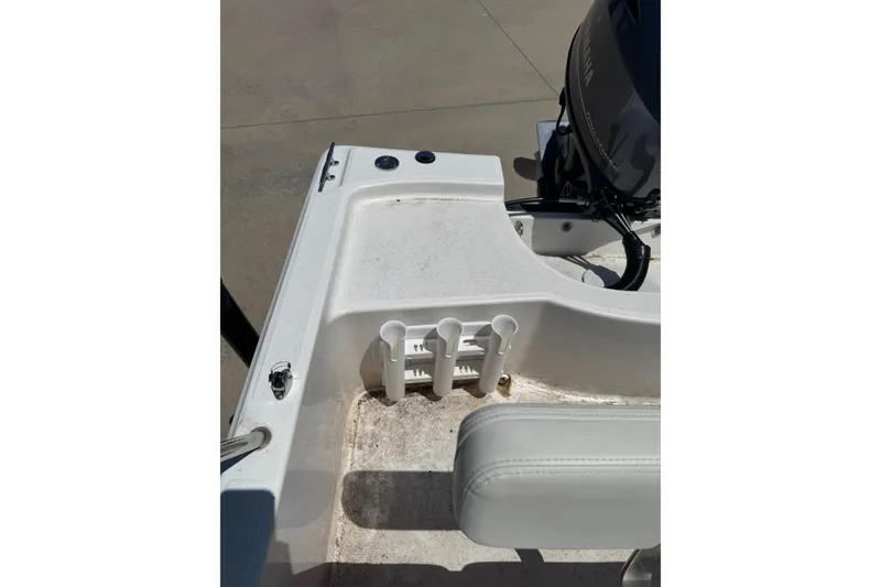 Slide: The Image of 2018 Edgewater 158CS boat interior with rod holders and motor detail. - 11