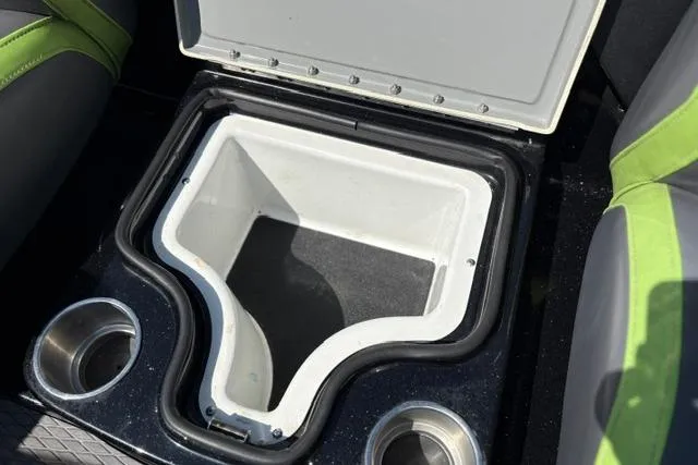 Slide: The Image of 2023 Caymas CX 20 PRO boat cooler compartment with cup holders and green-accented seating. - 21