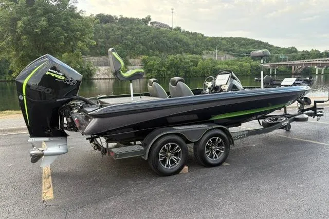 Slide: The Image of 2023 Caymas CX 20 PRO boat on trailer, parked near a scenic river backdrop. - 13