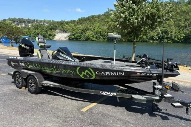 Slide: The Image of 2023 Caymas CX 20 PRO boat with Garmin branding, parked near a scenic river. - 2