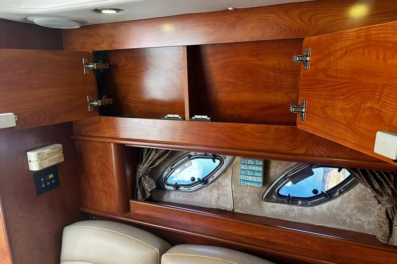 Slide: The Image of Interior of 2012 Rinker 310 Express Cruiser LE with wooden cabinets and porthole windows. - 38