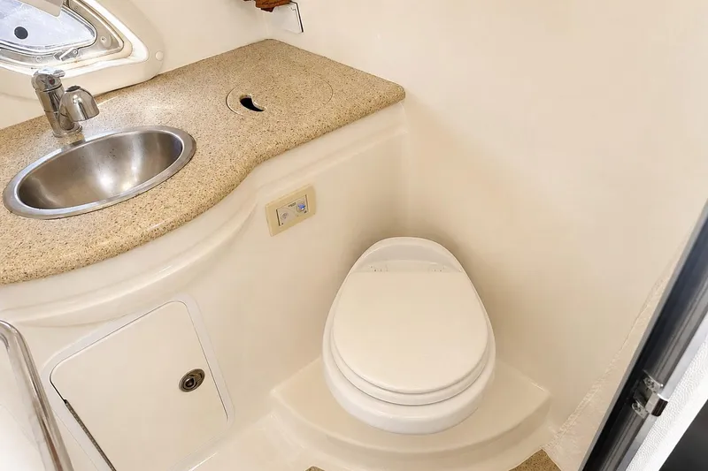 Slide: The Image of Bathroom interior of 2012 Rinker 310 Express Cruiser LE with sink and toilet. - 52