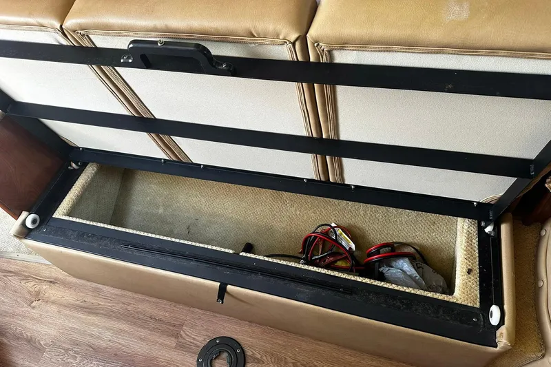 Slide: The Image of Open storage compartment in 2012 Rinker 310 Express Cruiser LE boat, showing cables inside. - 37