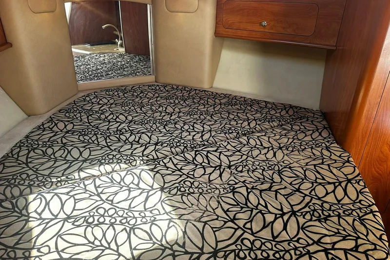 Slide: The Image of Interior of 2012 Rinker 310 Express Cruiser LE with patterned carpet and wooden cabinetry. - 40