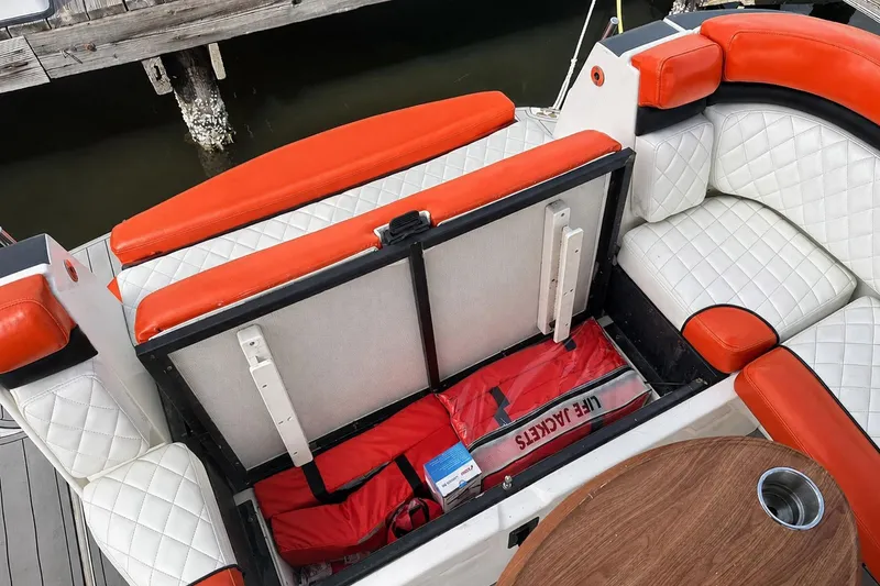 Slide: The Image of 2012 Rinker 310 Express Cruiser LE with open storage, life jackets, and cushioned seating. - 19