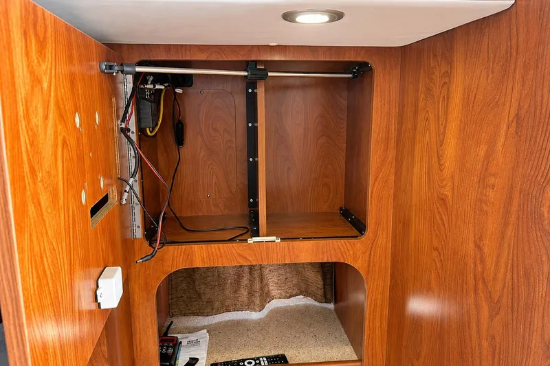 Slide: The Image of Interior of 2012 Rinker 310 Express Cruiser LE with wooden cabinetry and wiring setup. - 50