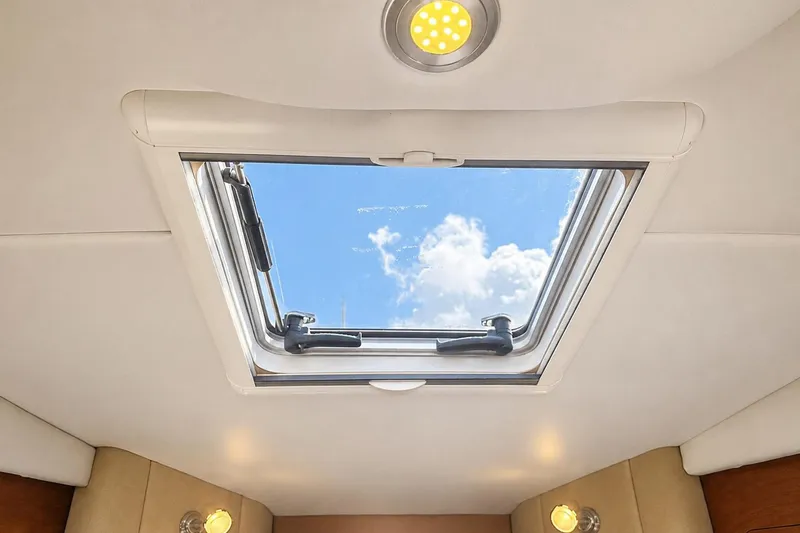 Slide: The Image of Interior view of 2012 Rinker 310 Express Cruiser LE skylight with blue sky and clouds. - 43
