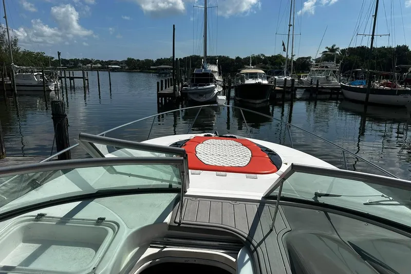 Slide: The Image of 2012 Rinker 310 Express Cruiser LE docked in a serene marina setting. - 30