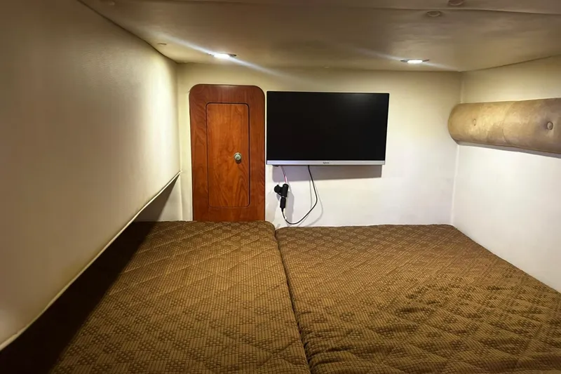Slide: The Image of Interior cabin of 2012 Rinker 310 Express Cruiser LE with TV and cozy bedding. - 35