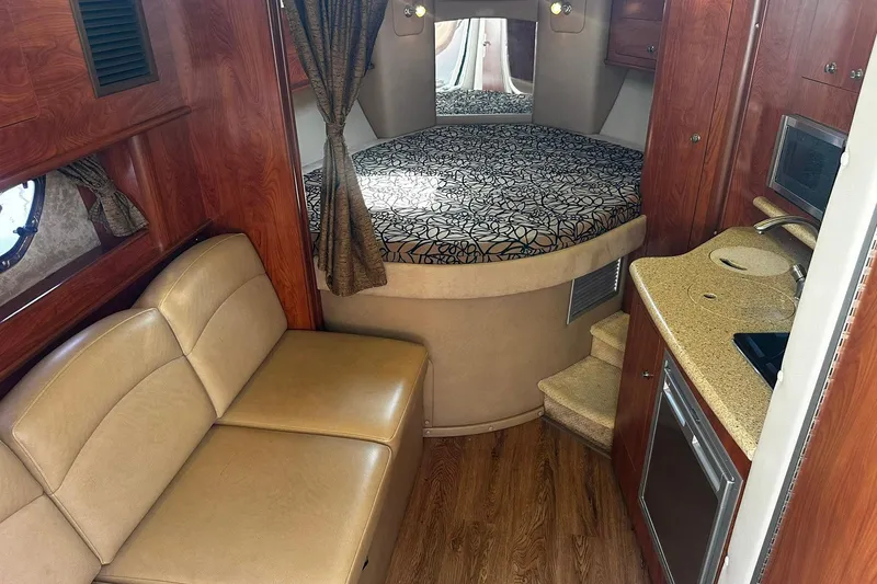 Slide: The Image of Interior of 2012 Rinker 310 Express Cruiser LE with cozy seating and compact kitchenette. - 31