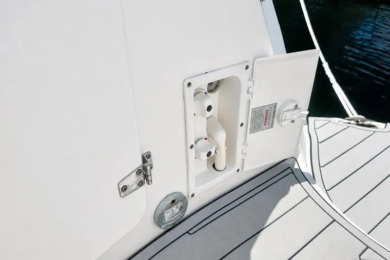 Slide: The Image of 2012 Rinker 310 Express Cruiser LE water hookup compartment on deck. - 16
