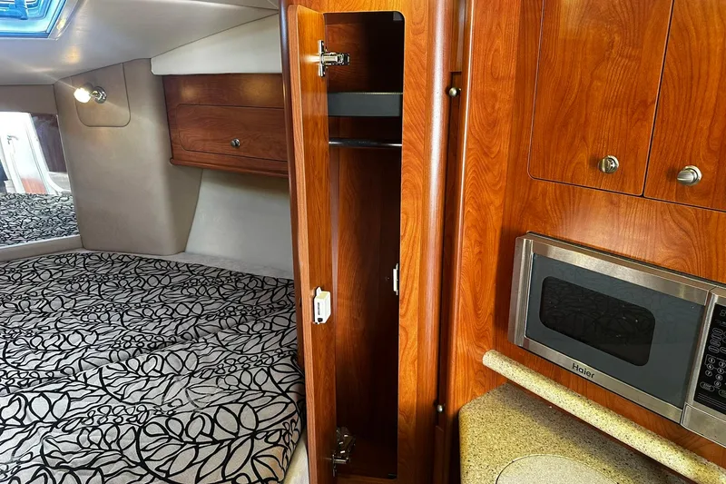 Slide: The Image of Interior of 2012 Rinker 310 Express Cruiser LE with wood cabinetry and microwave. - 44