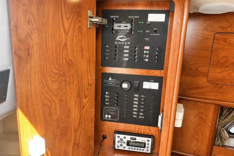 Slide: The Image of 2012 Rinker 310 Express Cruiser LE electrical panel with wood finish. - 57