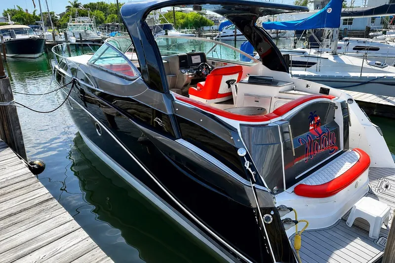 Slide: The Image of 2012 Rinker 310 Express Cruiser LE docked at marina, featuring sleek design and vibrant interior. - 7