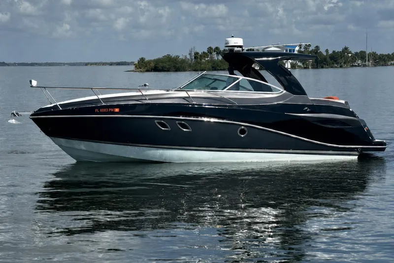 Slide: The Image of 2012 Rinker 310 Express Cruiser LE on calm water, sleek design, and modern features. - 3