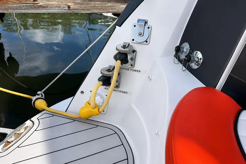 Slide: The Image of 2012 Rinker 310 Express Cruiser LE shore power connections with yellow cables and red seating. - 11