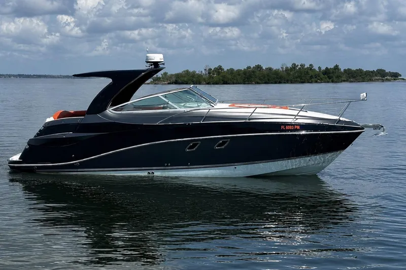 Slide: The Image of 2012 Rinker 310 Express Cruiser LE on calm water under cloudy sky. - 5