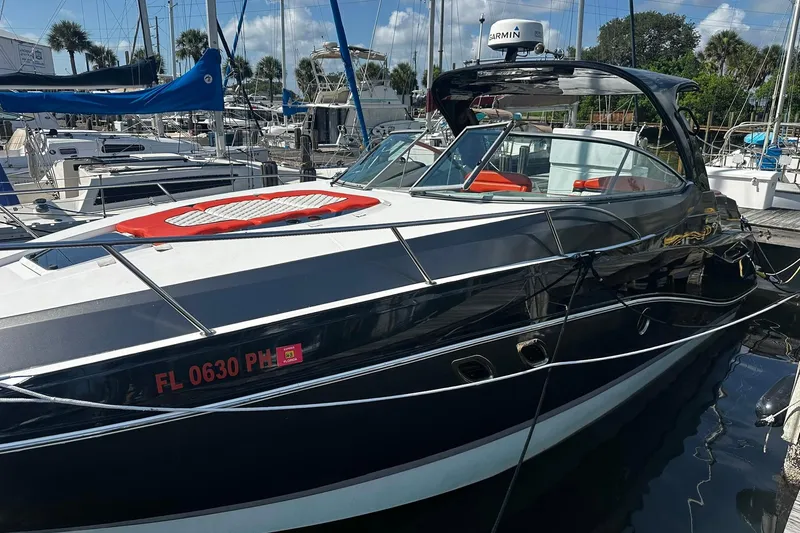 Slide: The Image of 2012 Rinker 310 Express Cruiser LE docked at marina, sleek design, sunny day. - 8