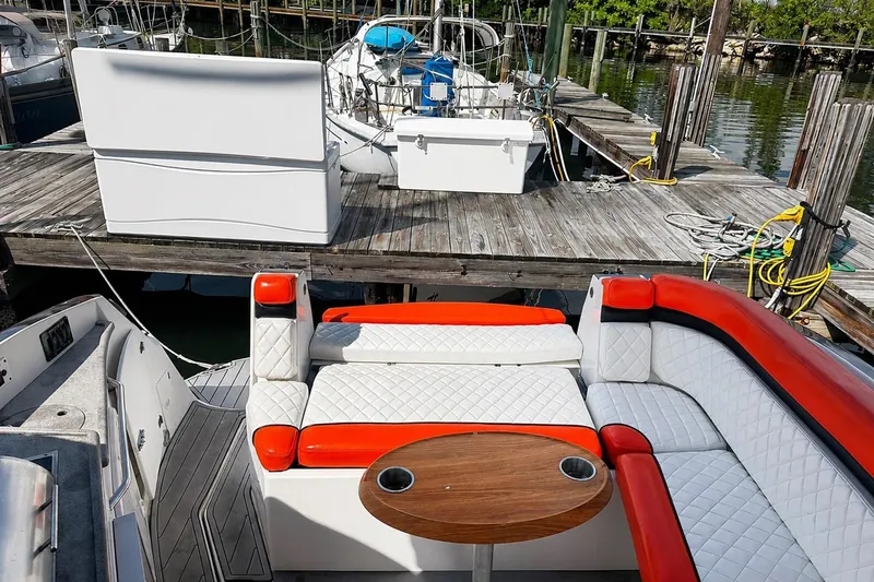 Slide: The Image of 2012 Rinker 310 Express Cruiser LE with red and white seating at a dock. - 18