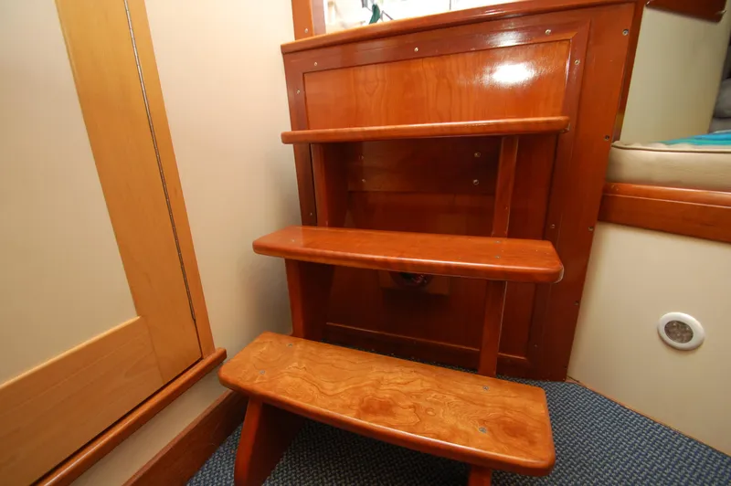 Slide: The Image of Wooden steps inside a boat, with carpeted floor and wooden walls. - 19