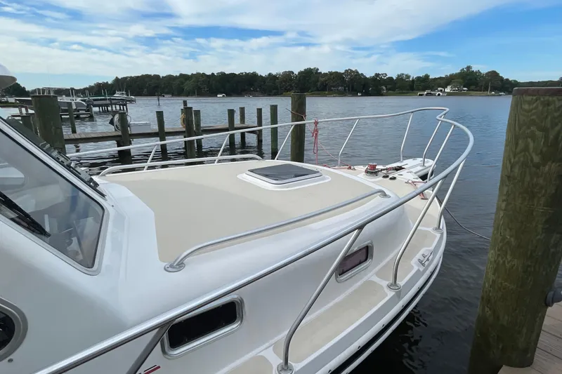 Slide: The Image of 2005 Fox Island Thirty Sedan Cruiser docked by a serene waterfront. - 4
