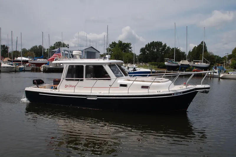The Image of A 2005 Fox Island Thirty Sedan Cruiser on calm water in a harbor. - 0