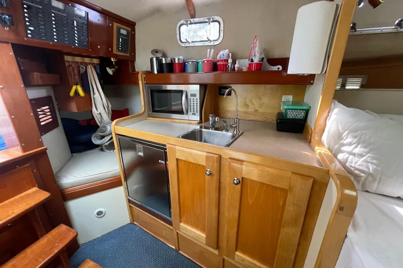 Slide: The Image of Compact galley kitchen in 2005 Fox Island Thirty Sedan Cruiser with microwave and sink. - 34