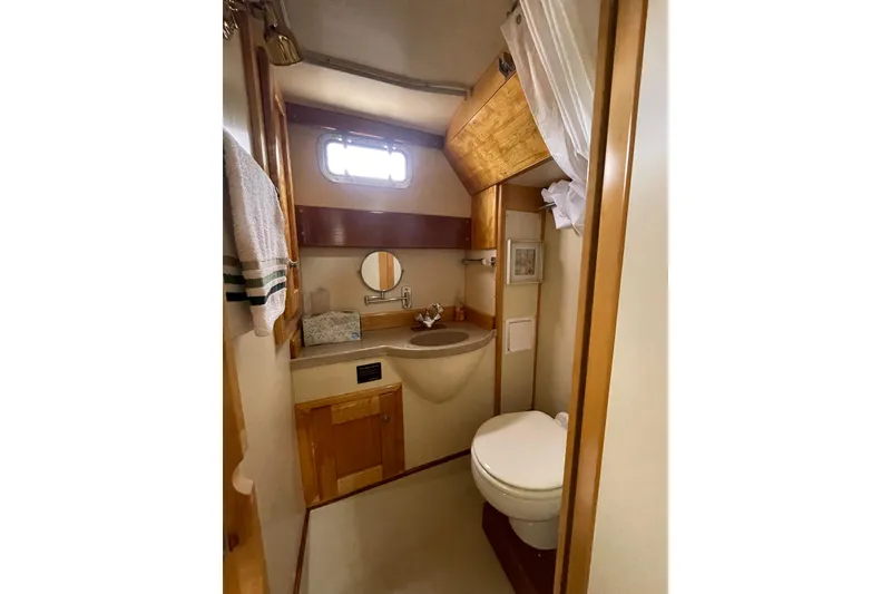 Slide: The Image of Bathroom interior of 2005 Fox Island Thirty Sedan Cruiser, featuring sink, toilet, and wooden cabinetry. - 33