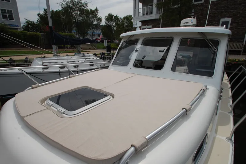 Slide: The Image of A 2005 Fox Island Thirty Sedan Cruiser docked. The boat features a beige deck. - 21