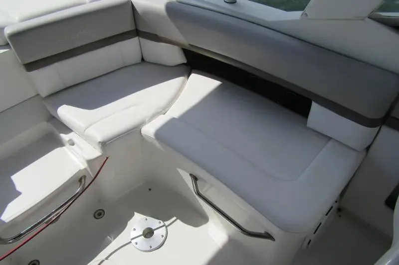 Slide: The Image of Interior seating of a 2011 Sea Ray SLX 250 boat, featuring white and gray upholstery. - 34