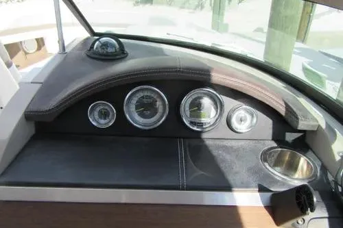 Slide: The Image of Dashboard of a 2011 Sea Ray SLX 250 boat with gauges and cup holder. - 19