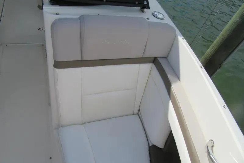 Slide: The Image of 2011 Sea Ray SLX 250 boat interior with cushioned seating by the water. - 16