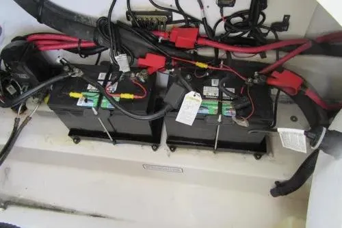 Slide: The Image of 2011 Sea Ray SLX 250 boat battery compartment with wiring and dual batteries. - 10
