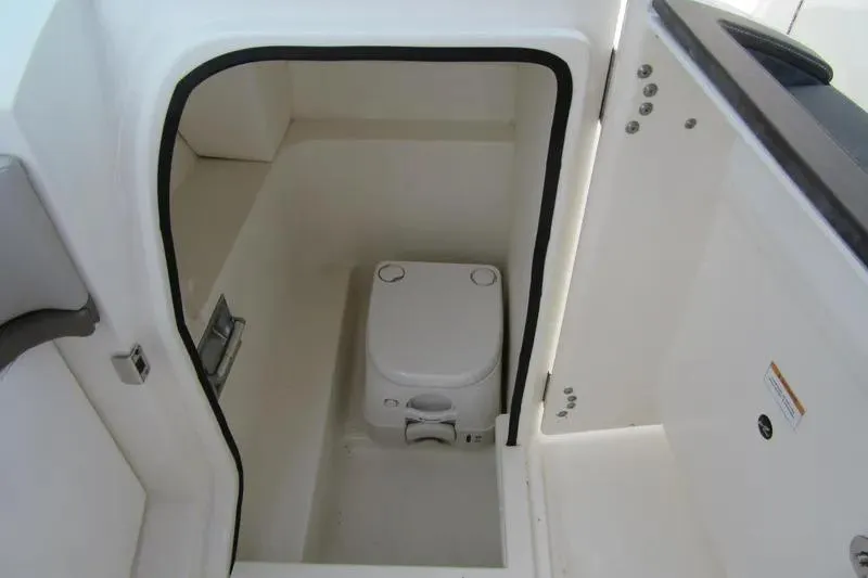 Slide: The Image of Interior view of a 2011 Sea Ray SLX 250 boat's compact marine toilet. - 29