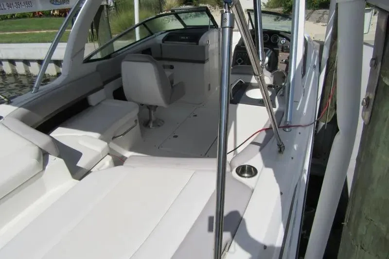 Slide: The Image of 2011 Sea Ray SLX 250 boat interior with seating and helm, docked by the water. - 38