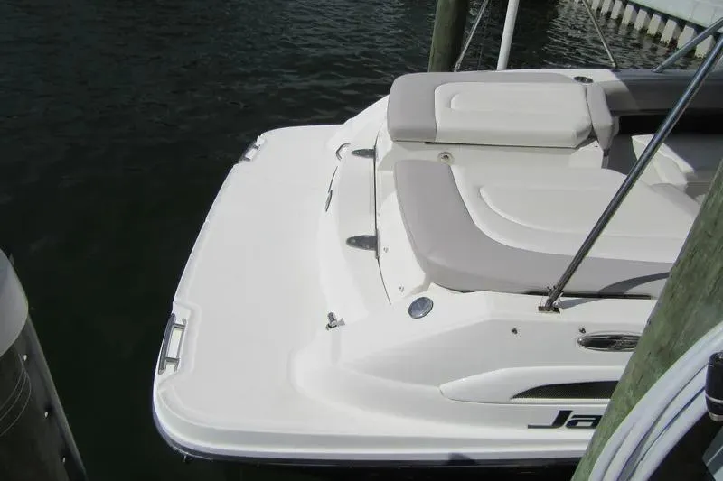 Slide: The Image of 2011 Sea Ray SLX 250 boat docked, featuring spacious rear seating and swim platform. - 36