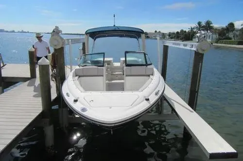 Slide: The Image of 2011 Sea Ray SLX 250 boat docked on a lift, sunny waterfront view. - 4