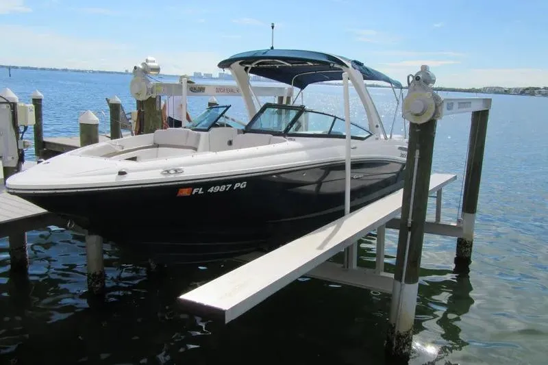 The Image of 2011 Sea Ray SLX 250 boat docked on a lift by the water. - 1