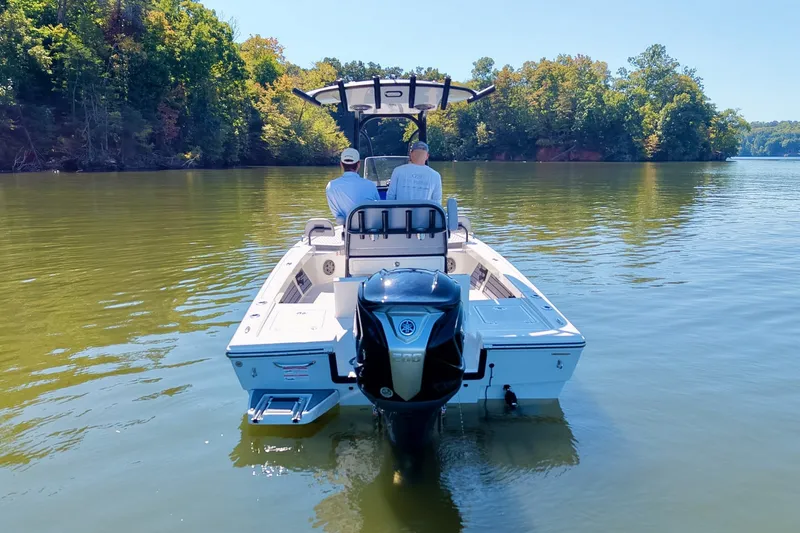 Slide: The Image of Pathfinder 2200 Hybrid boat cruising on a serene lake, surrounded by lush trees. - 10
