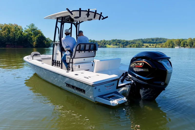 Slide: The Image of 2027 Pathfinder 2200 Hybrid boat on a serene lake with two passengers. - 4