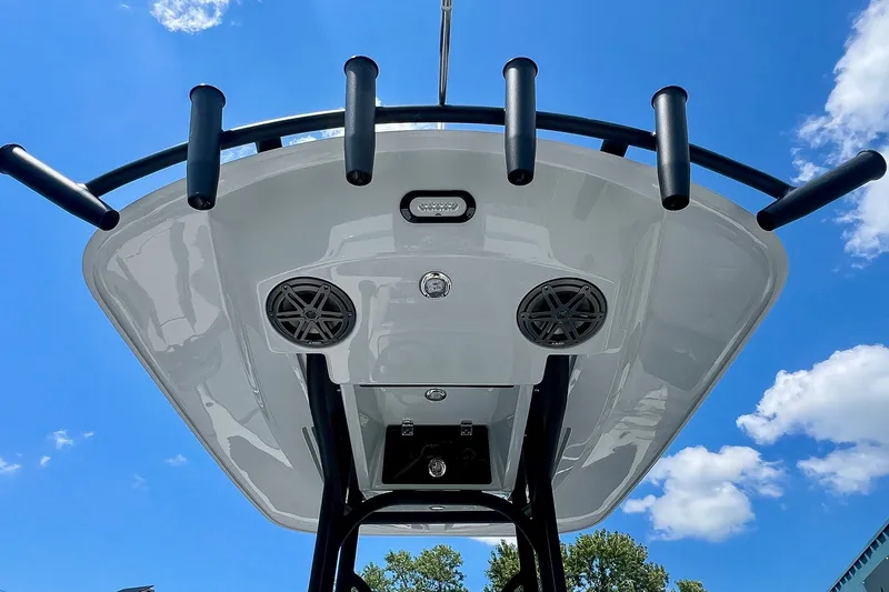 Slide: The Image of 2027 Pathfinder 2200 TRS boat T-top with rod holders and speakers against blue sky. - 21