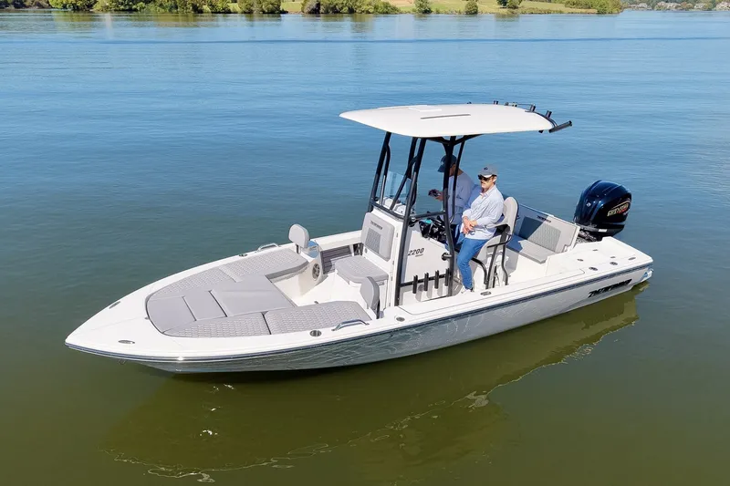 Slide: The Image of 2027 Pathfinder 2200 Hybrid boat on calm water, featuring modern design and spacious deck. - 32