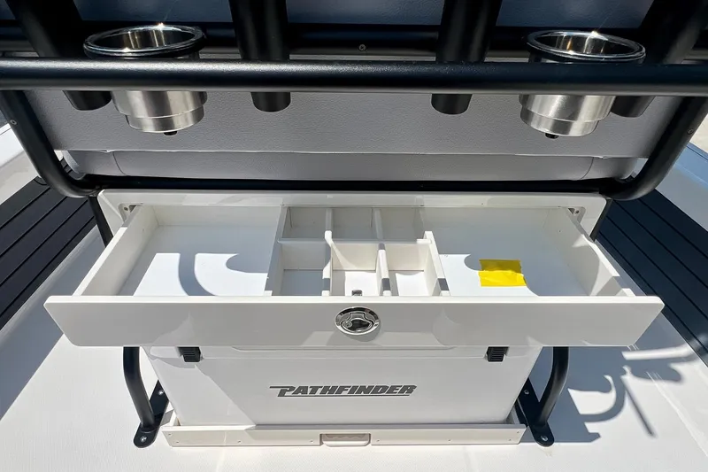 Slide: The Image of Open storage compartment on a 2027 Pathfinder 2200 TRS boat with cup holders above. - 17