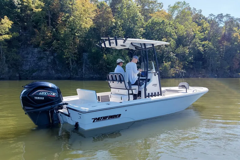 Slide: The Image of 2027 Pathfinder 2200 Hybrid boat on calm water, surrounded by lush trees. - 28