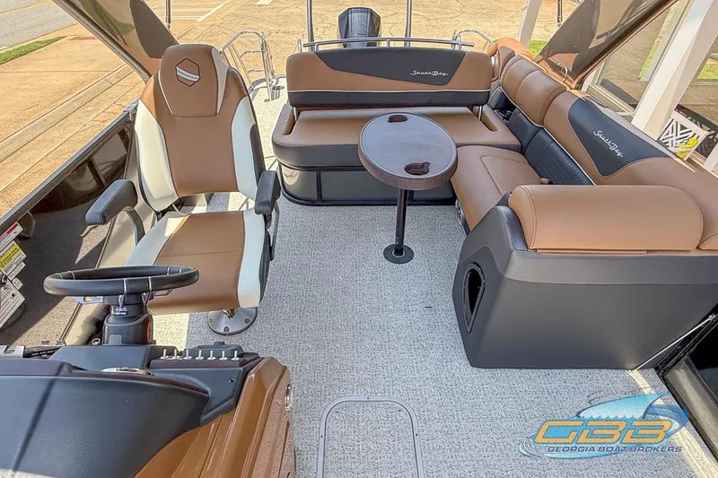 Slide: The Image of 2022 South Bay 523 SB2 ARCH boat interior with brown seating and steering console. - 6