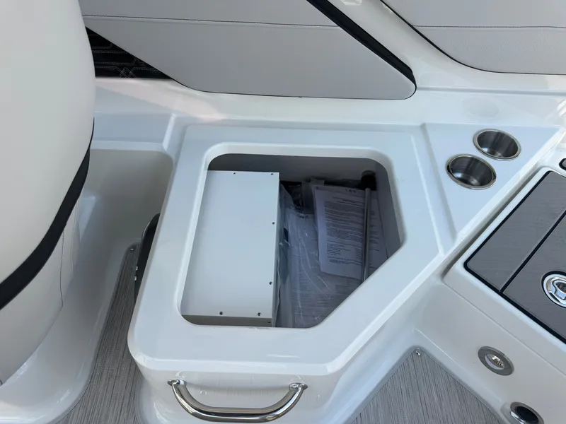 Slide: The Image of An open storage compartment on a Sea Ray SPX 210 boat with papers and a metal handle. - 31
