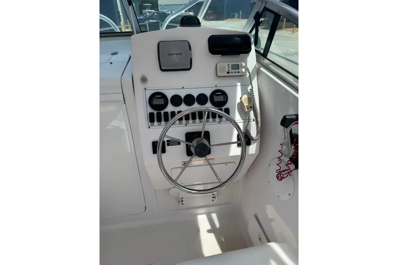 Slide: The Image of 2006 Pro-Line 24 Walkaround boat helm with steering wheel and navigation instruments. - 10