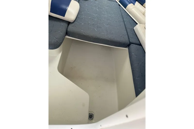 Slide: The Image of 2006 Pro-Line 24 Walkaround boat interior with blue cushioned seating and storage area. - 23